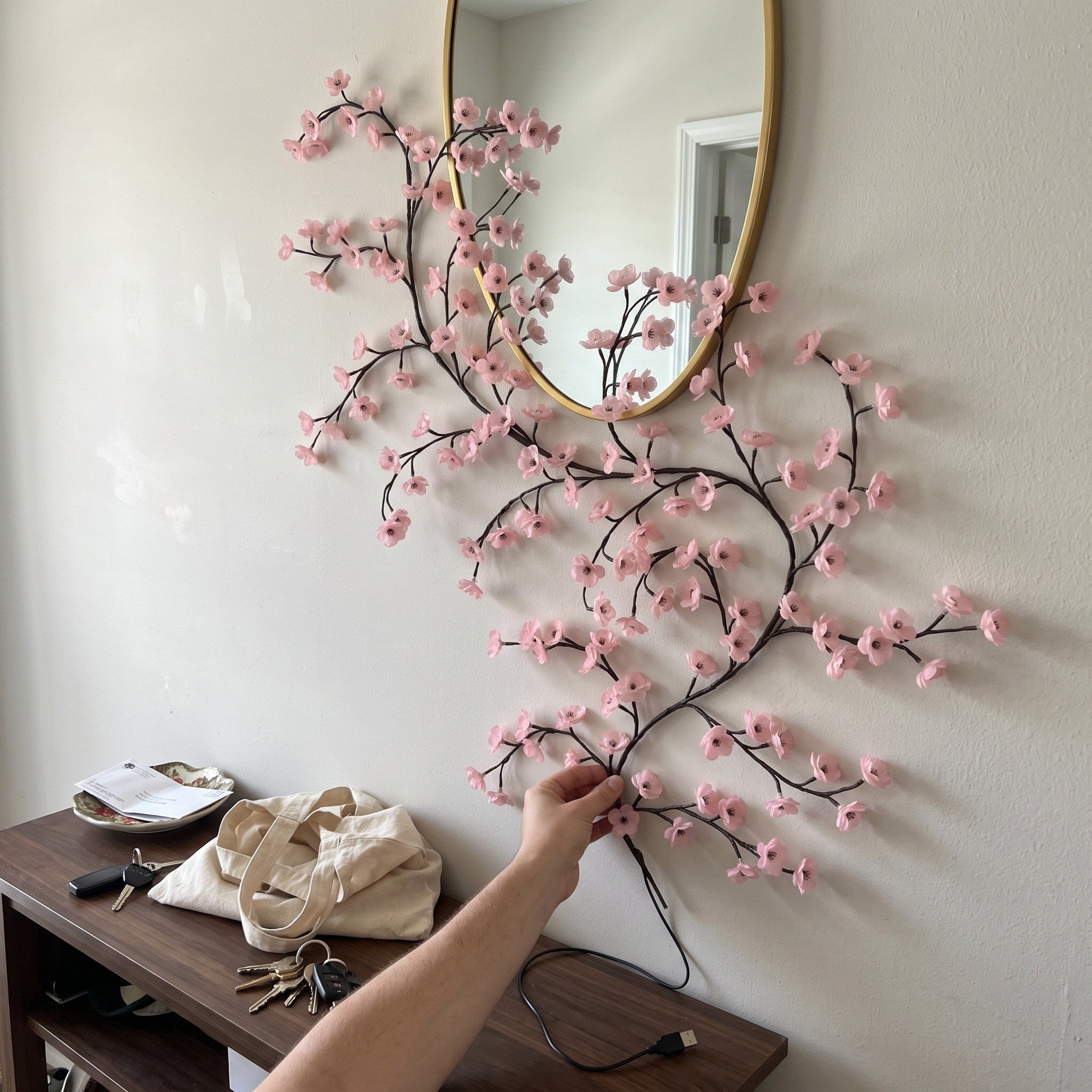 Pink blossom vine around an entry mirror in daylight